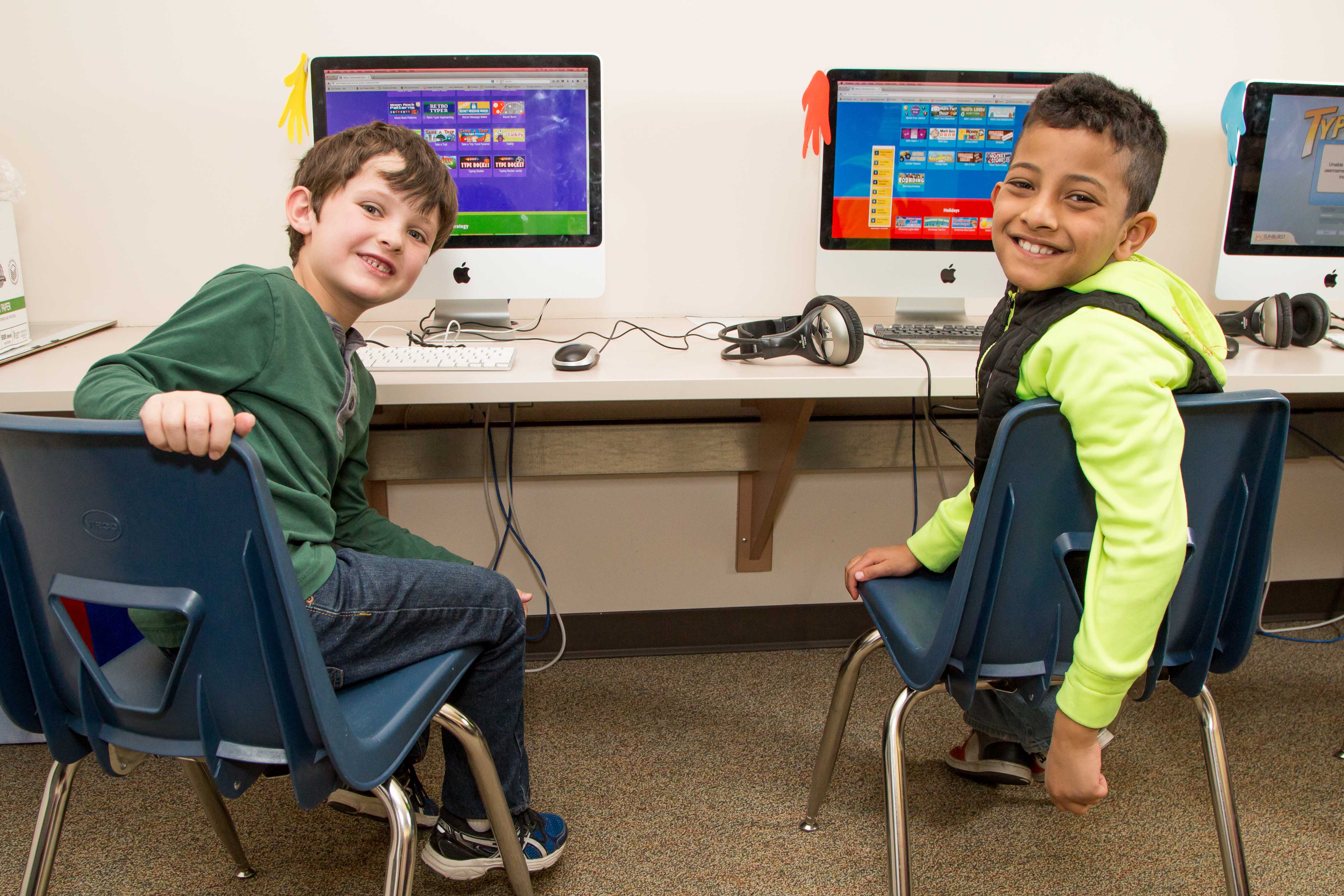 Two students smiling at a computer lab 